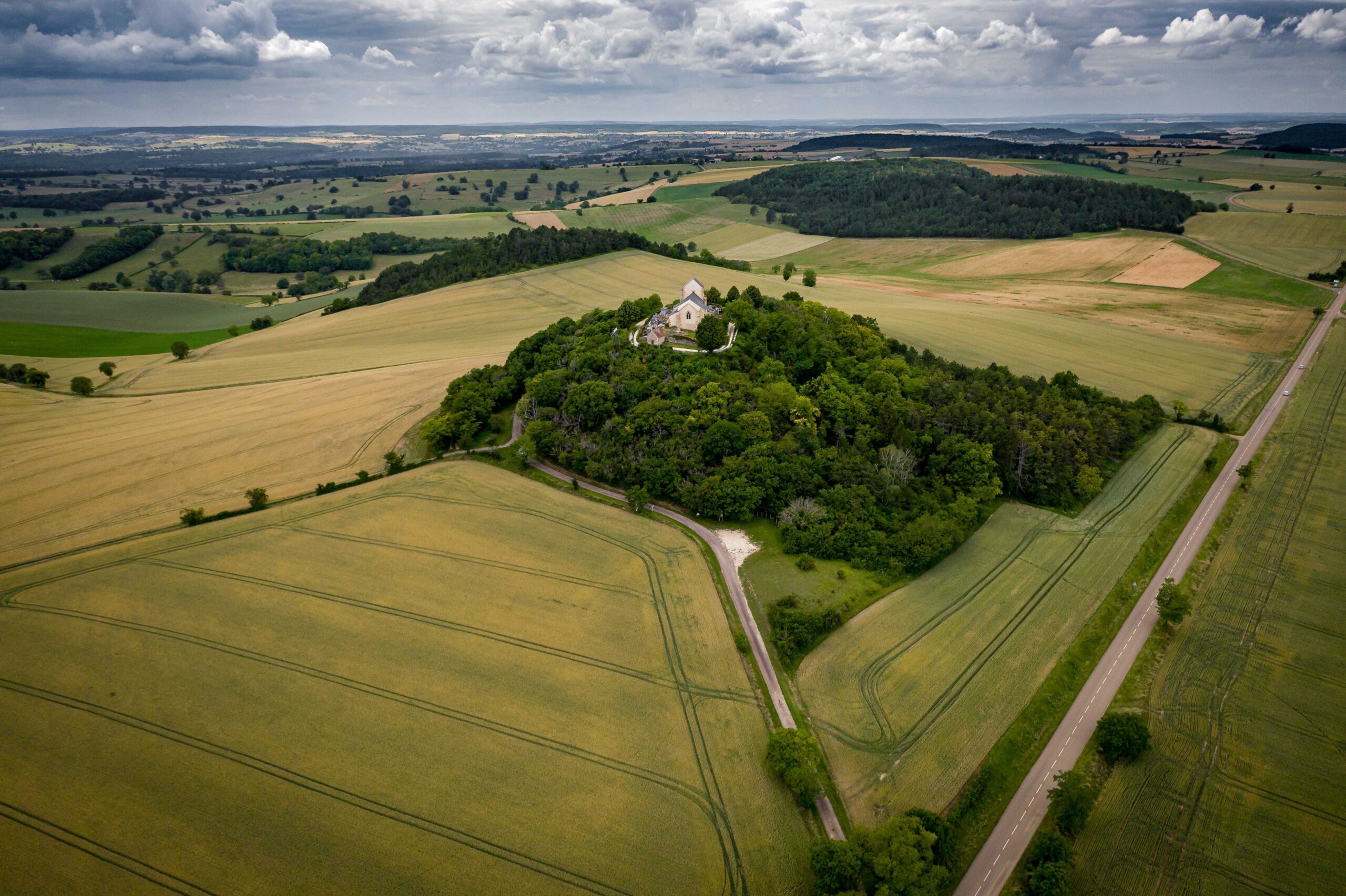 An aerial shot of a grassland under during a cloudy weather